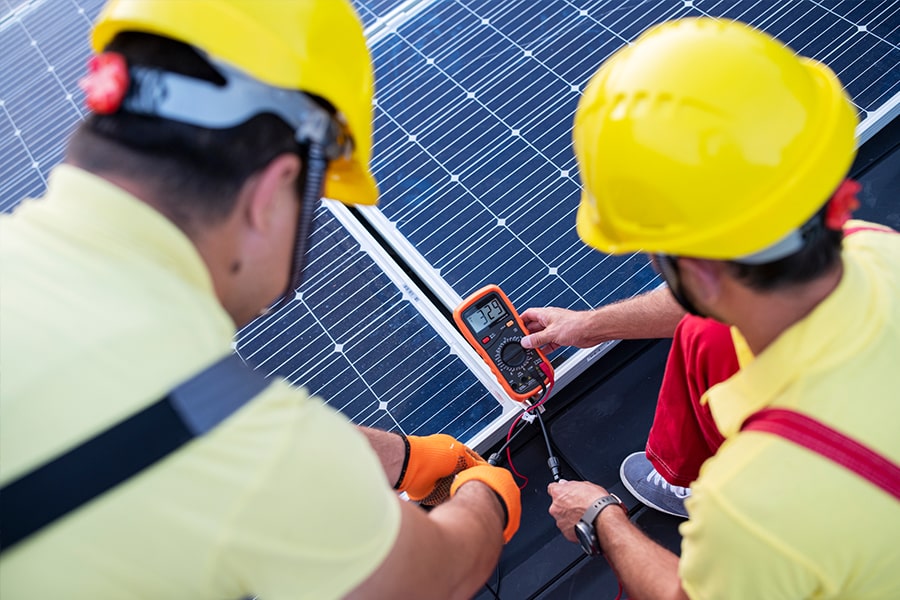 solar engineers using multi meter on PV panels