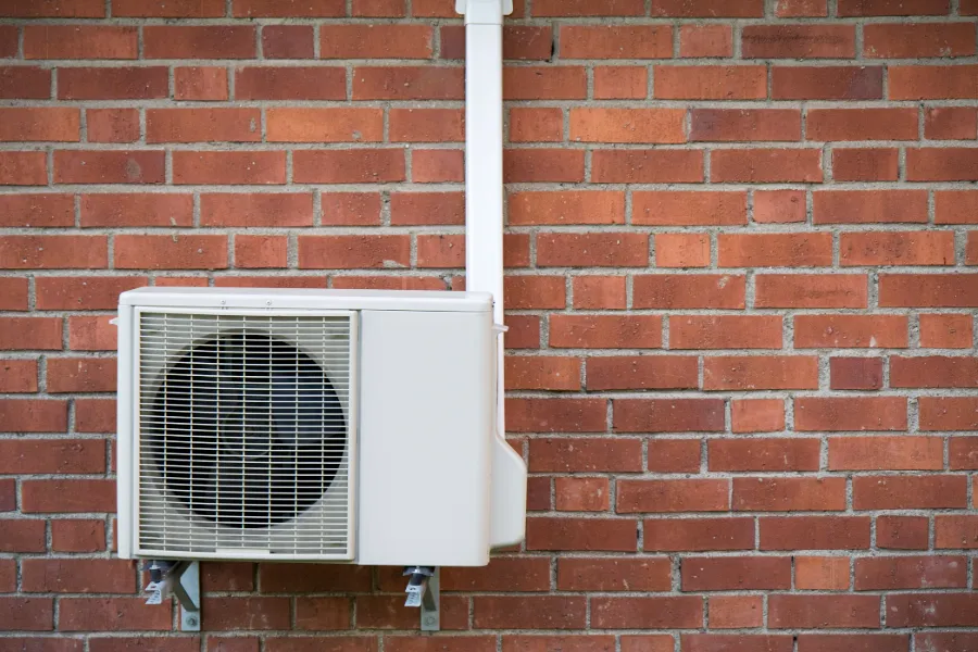 Ai Source Heat Pump on a Brick Wall